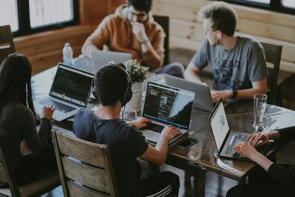 Colleagues working on laptops around a shared table